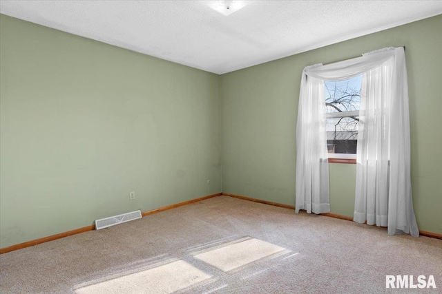 carpeted spare room with a textured ceiling