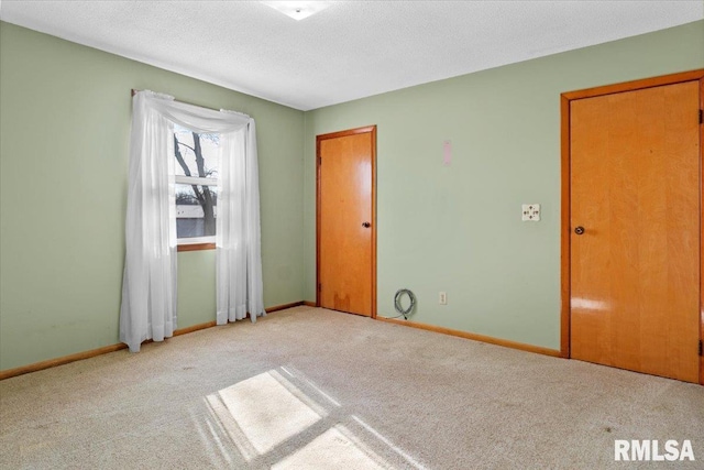 empty room featuring light colored carpet and a textured ceiling