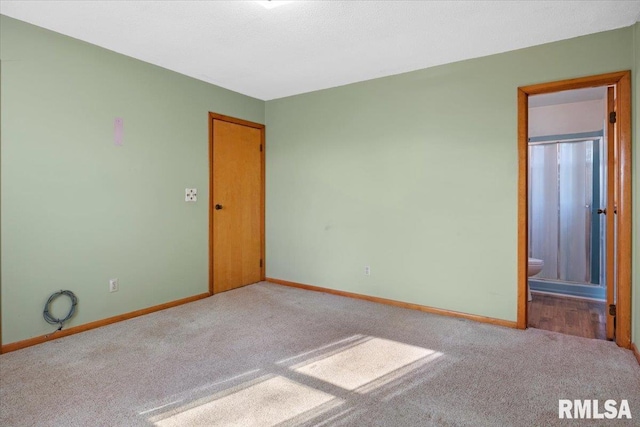 unfurnished bedroom featuring carpet flooring and connected bathroom