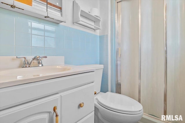 bathroom with vanity, tile walls, an enclosed shower, and toilet