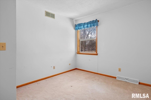 empty room featuring carpet flooring and a textured ceiling