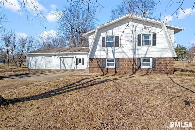 rear view of property featuring a garage and a yard