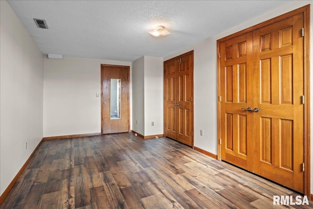 spare room featuring hardwood / wood-style floors and a textured ceiling