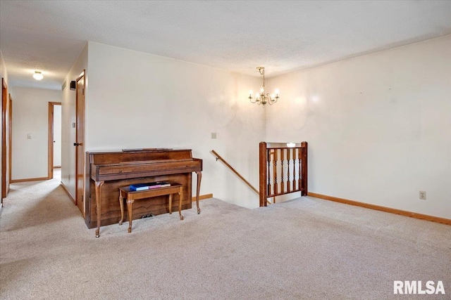 misc room featuring a chandelier, light carpet, and a textured ceiling