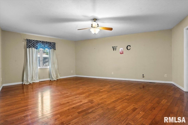 unfurnished room with ceiling fan, baseboards, a textured ceiling, and hardwood / wood-style floors