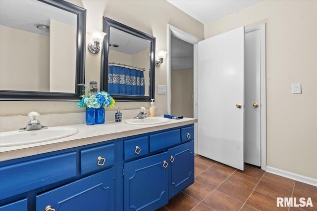 full bathroom featuring a sink, double vanity, and tile patterned flooring