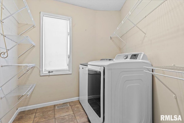 laundry area featuring visible vents, independent washer and dryer, light tile patterned floors, baseboards, and laundry area