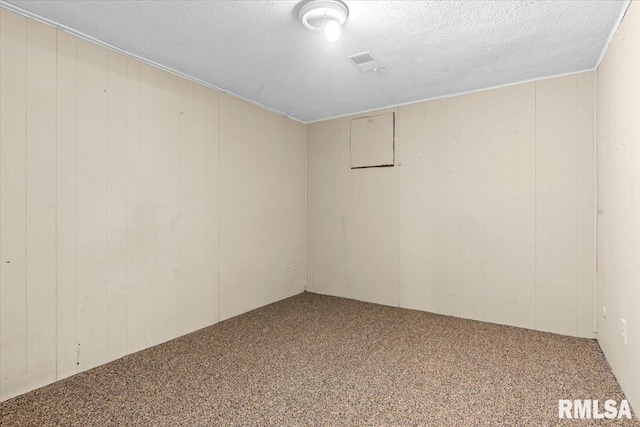 spare room with visible vents, a textured ceiling, and carpet floors