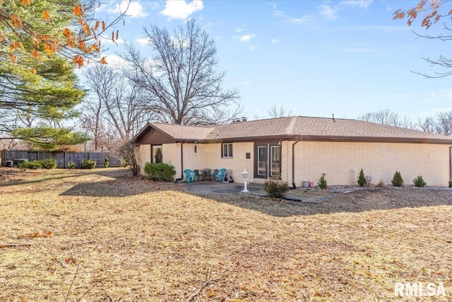 back of property with a patio area, brick siding, and fence