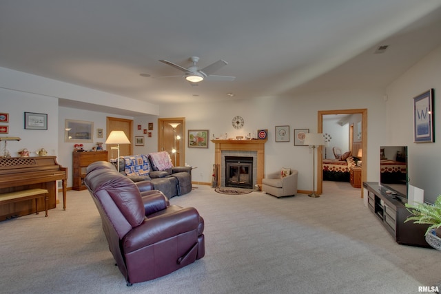 carpeted living room with ceiling fan and a fireplace