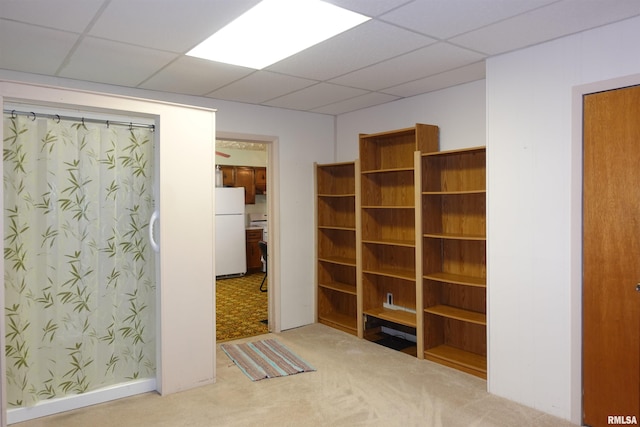 interior space with carpet floors and a paneled ceiling