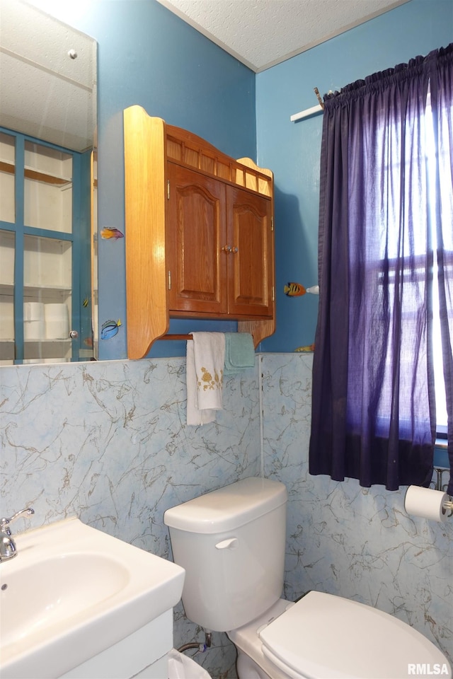 bathroom featuring vanity, toilet, and a textured ceiling