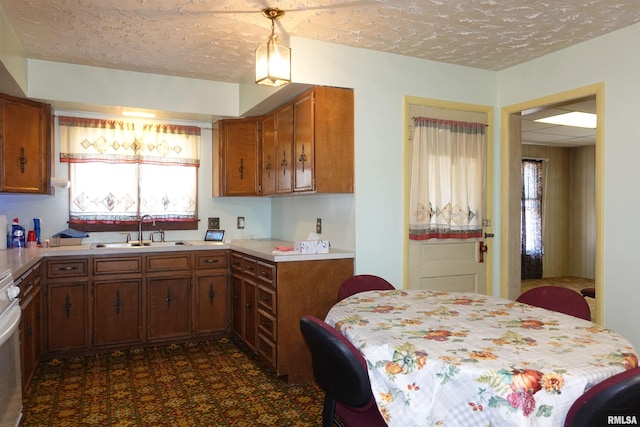 kitchen with stove, sink, and a textured ceiling