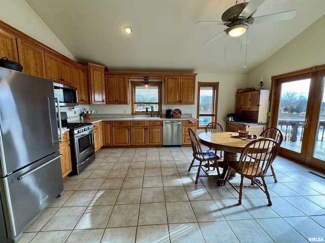 kitchen featuring lofted ceiling, appliances with stainless steel finishes, sink, and light tile patterned floors