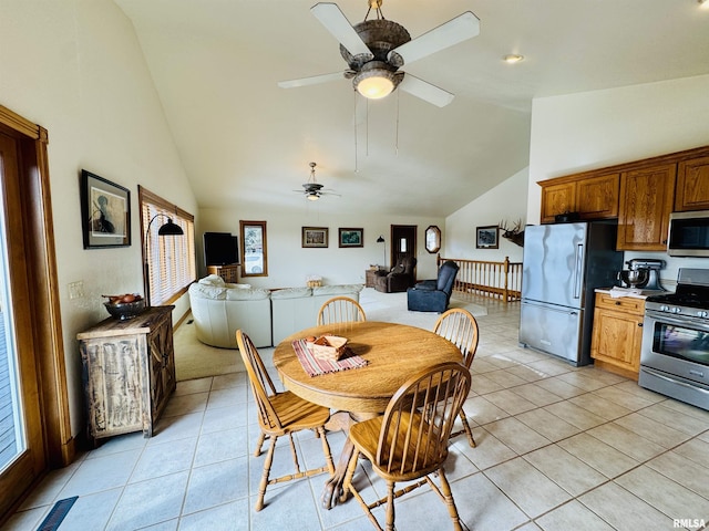 tiled dining area featuring ceiling fan and high vaulted ceiling