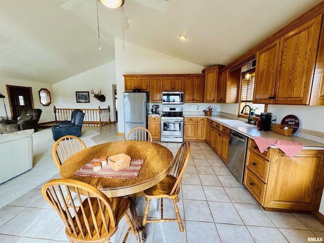 kitchen featuring light tile patterned flooring, appliances with stainless steel finishes, high vaulted ceiling, sink, and ceiling fan