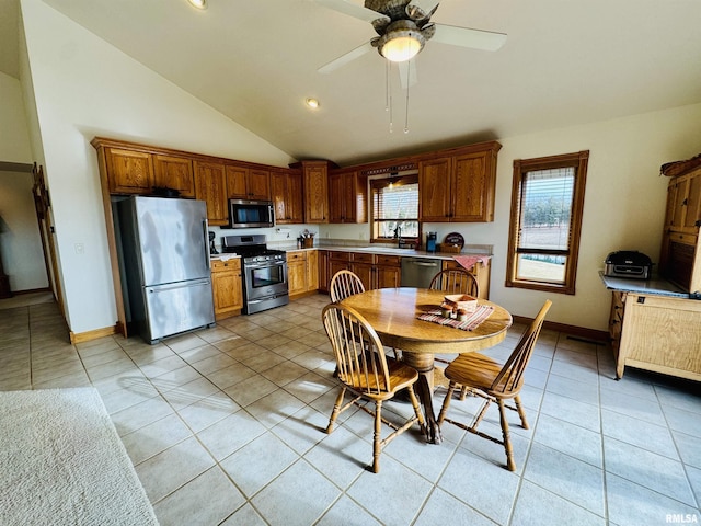 kitchen featuring sink, vaulted ceiling, light tile patterned floors, appliances with stainless steel finishes, and ceiling fan