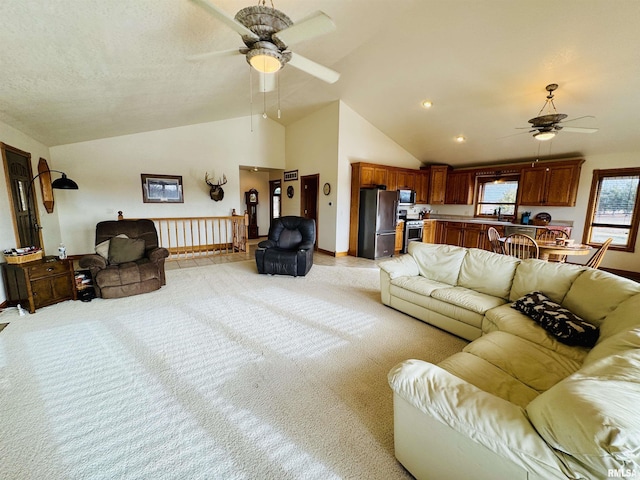 living room featuring vaulted ceiling, light colored carpet, and ceiling fan