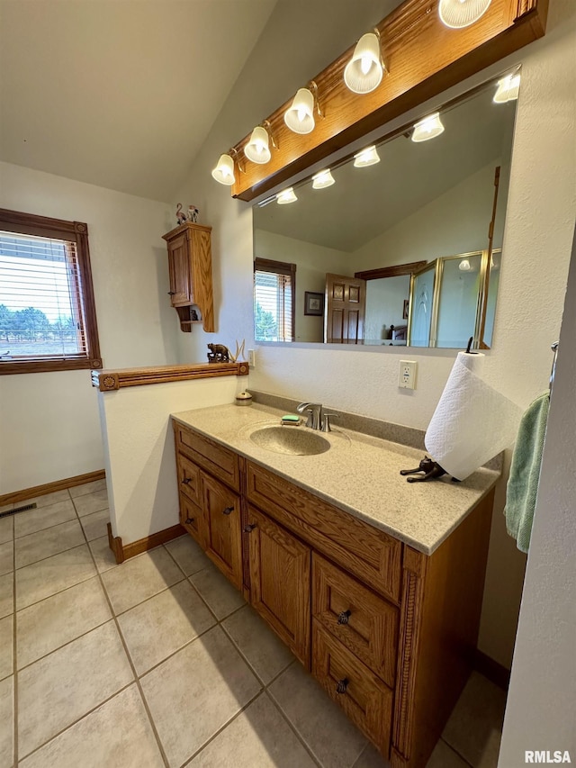 bathroom with tile patterned flooring, vaulted ceiling, and vanity