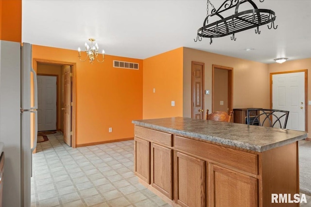 kitchen with white refrigerator, a center island, and an inviting chandelier