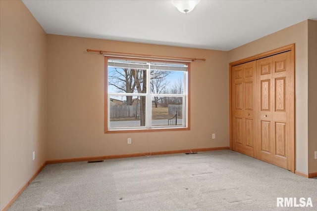 unfurnished bedroom featuring a closet and light carpet