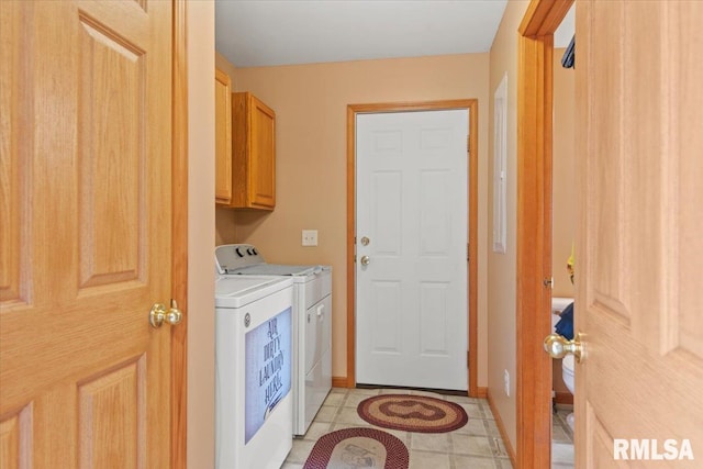 laundry room featuring independent washer and dryer, light tile patterned floors, and cabinets