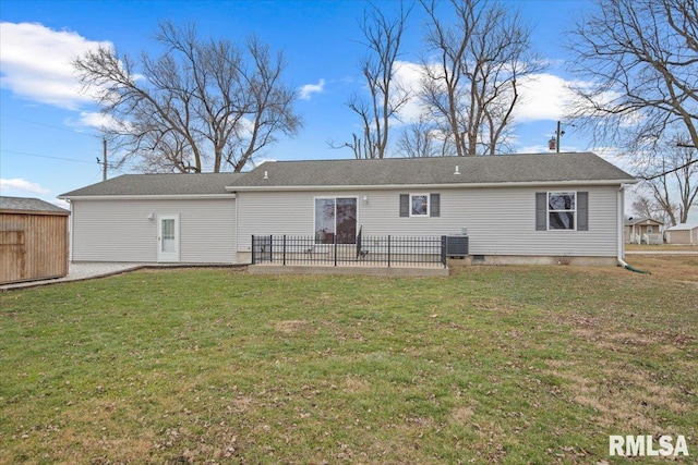 rear view of property with cooling unit and a yard