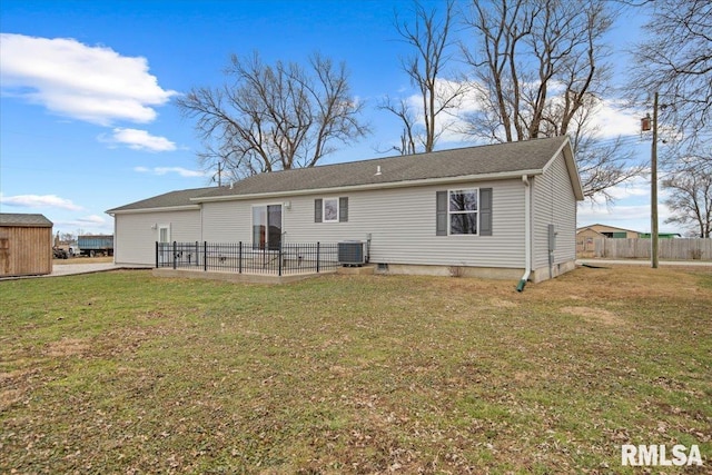 rear view of house with cooling unit and a lawn