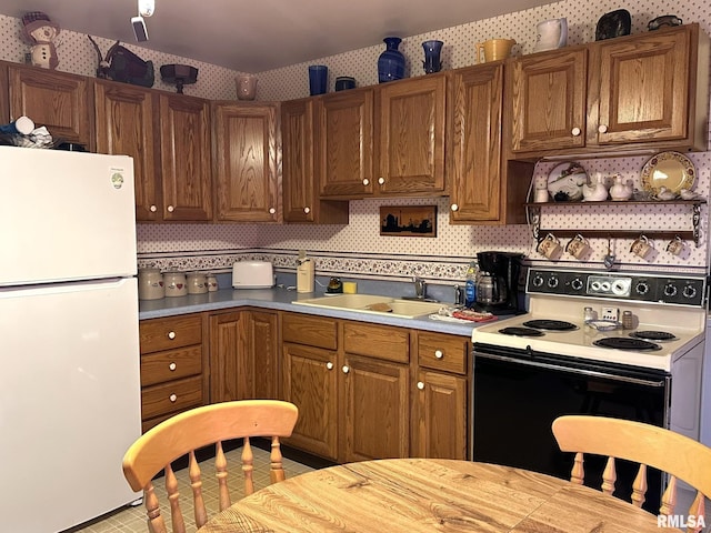 kitchen with white refrigerator, decorative backsplash, sink, and electric range oven