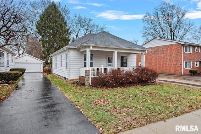 bungalow-style house featuring a garage, an outbuilding, covered porch, and a front lawn