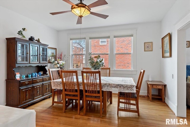 dining space with light hardwood / wood-style floors and ceiling fan