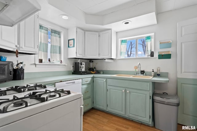 kitchen with sink, ventilation hood, white appliances, light hardwood / wood-style floors, and white cabinets