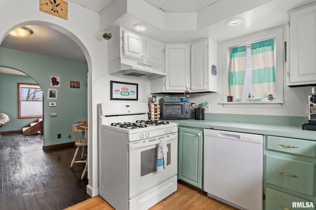 kitchen with white appliances, light hardwood / wood-style flooring, and white cabinets