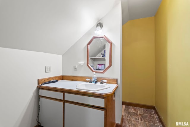 bathroom with lofted ceiling and vanity