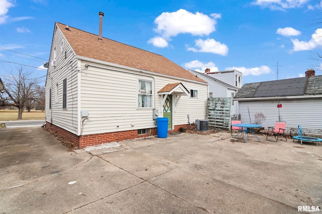 back of property with central AC and a patio area