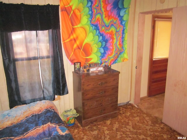 carpeted bedroom with wood walls