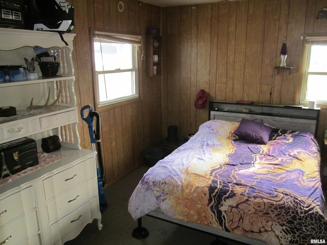 carpeted bedroom with wood walls