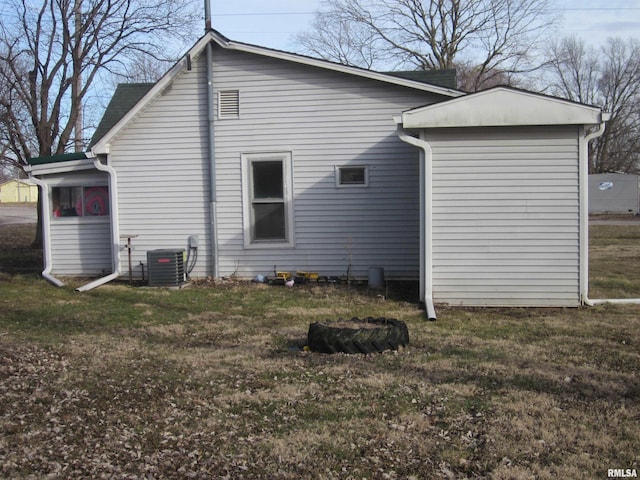 rear view of house with a lawn and central air condition unit