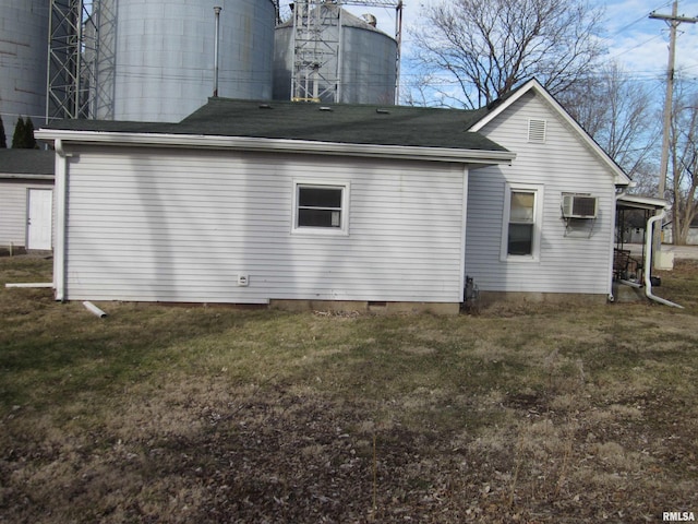 rear view of property with a lawn and an AC wall unit