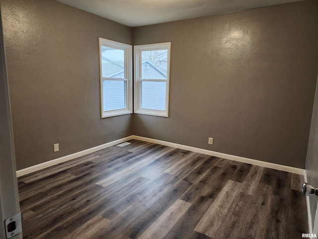 spare room featuring dark wood-type flooring