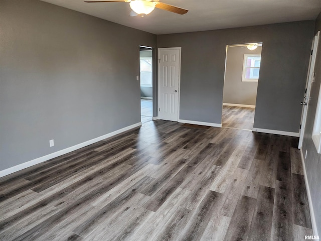 empty room featuring dark wood-type flooring and ceiling fan