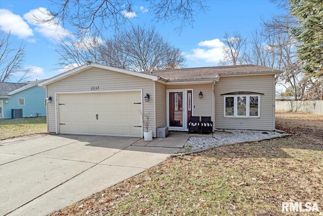 ranch-style house featuring central AC unit, a garage, and a front yard