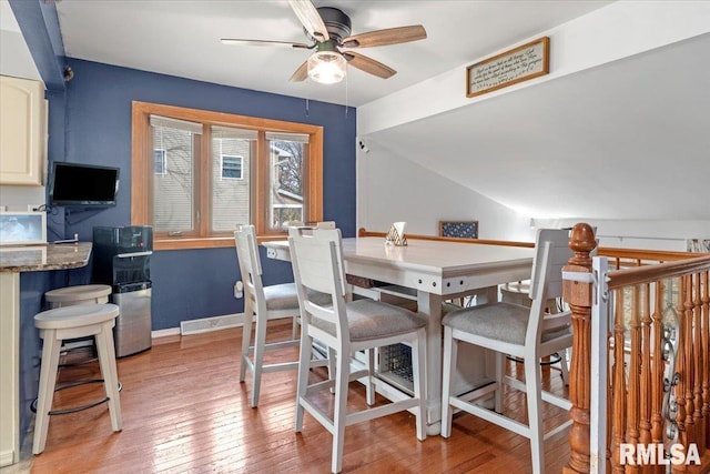 dining area with ceiling fan, lofted ceiling, and light hardwood / wood-style floors