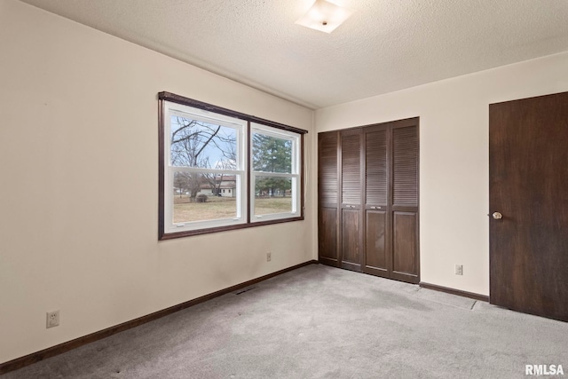 unfurnished bedroom featuring light colored carpet and a textured ceiling