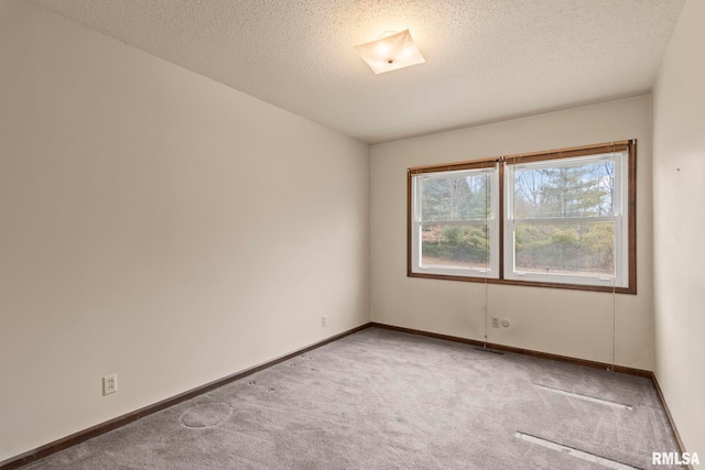 carpeted spare room featuring a textured ceiling