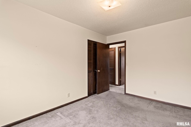 carpeted spare room featuring a textured ceiling