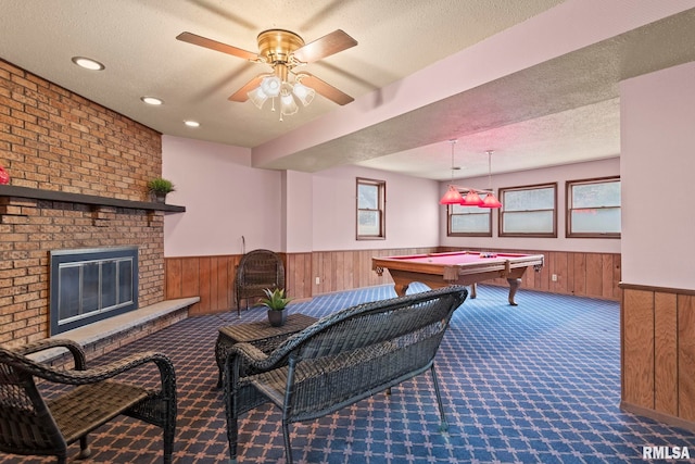 playroom featuring a healthy amount of sunlight, carpet floors, a textured ceiling, and wood walls