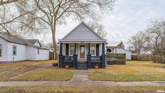 bungalow-style house featuring a porch, central AC, and a front lawn