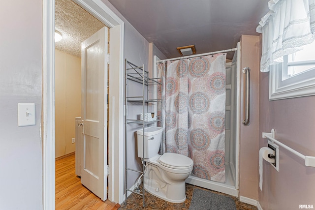 bathroom with hardwood / wood-style floors, curtained shower, toilet, and a textured ceiling