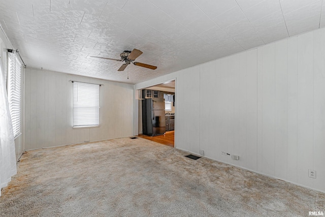 carpeted empty room featuring ceiling fan